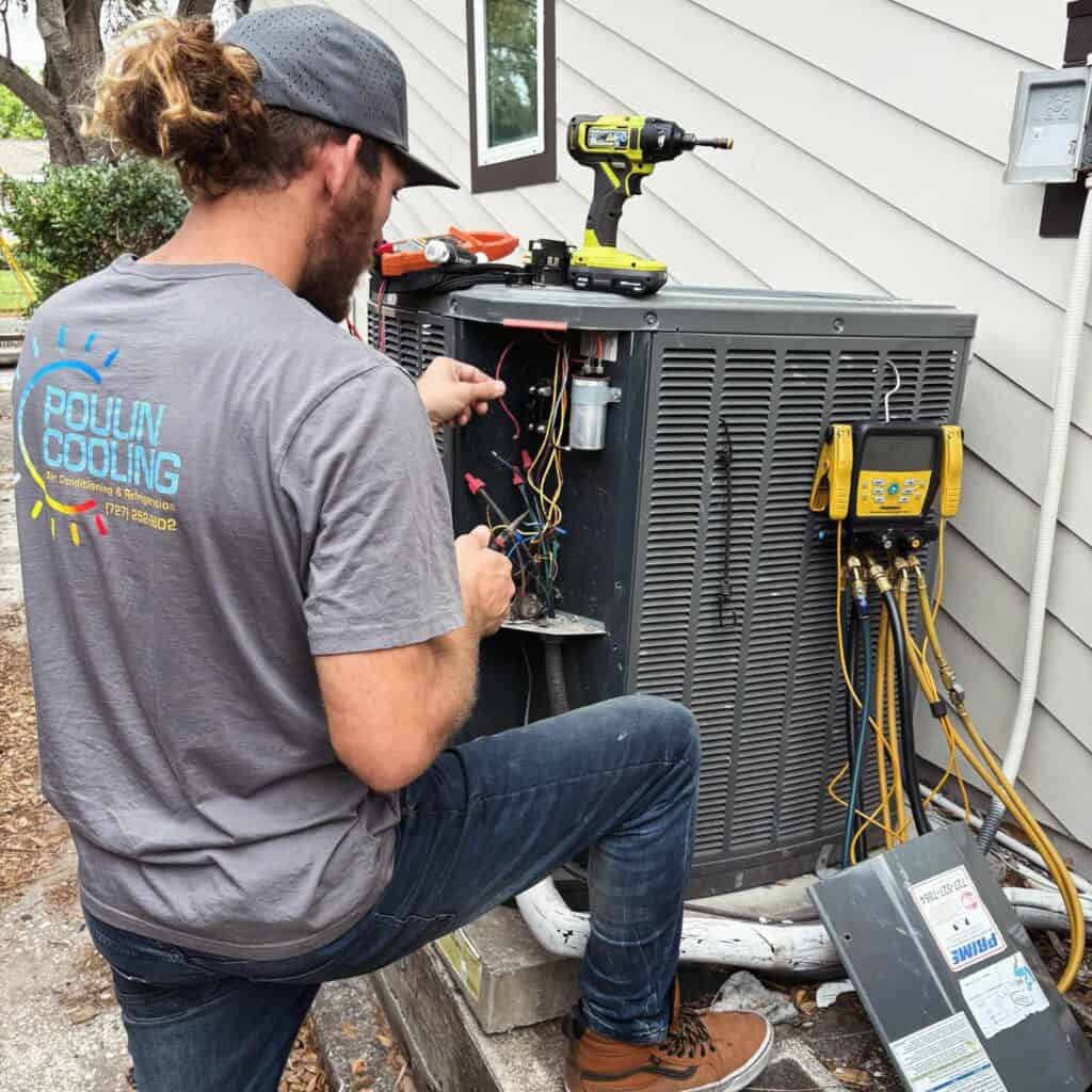 HVAC technician repairing air conditioning unit outside home.