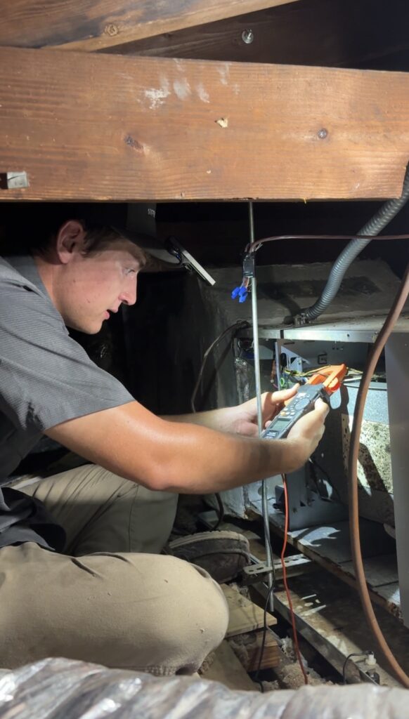 HVAC technician checking outdoor air conditioning condenser for maintenance.
