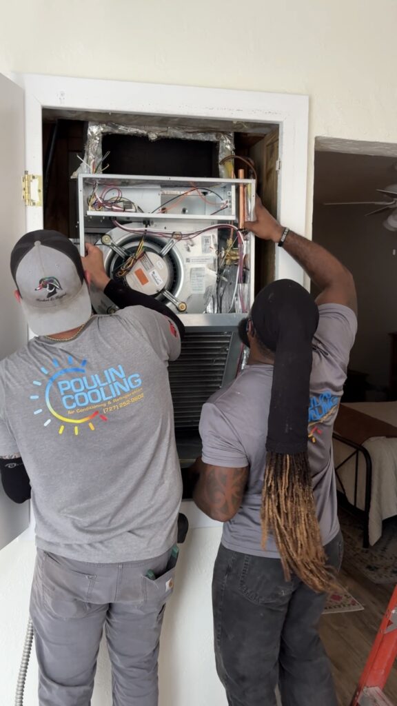Technicians inspecting and servicing an air conditioning unit for optimal performance.
