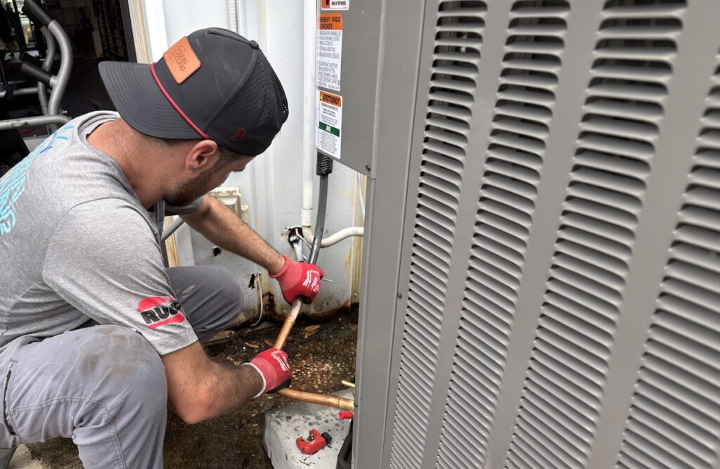 HVAC technician fixing outdoor AC unit in Clearwater.